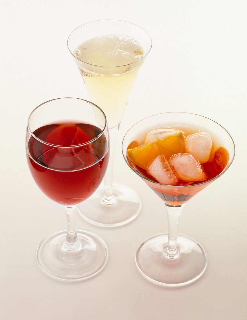 Three different drinks with prosecco, Aperol and red wine in glass against white platform