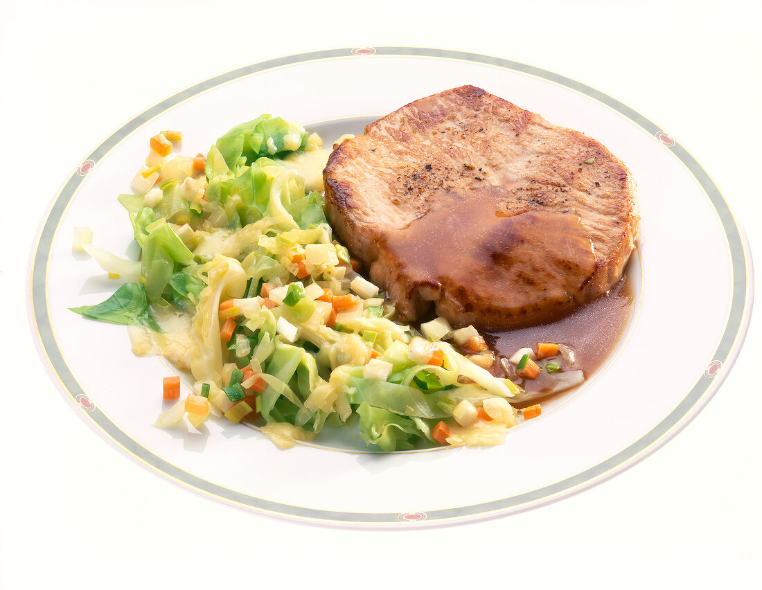 Pork steak with cabbage pieces and sauce on plate