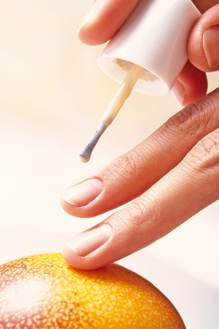 Close-up of woman applying nail polish on finger nails