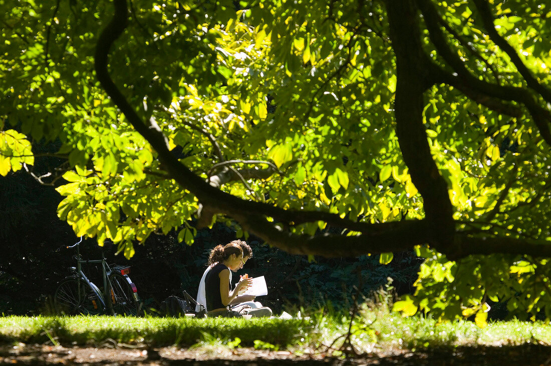 Couple sitting in meadow at Kung park, Malmo, Sweden