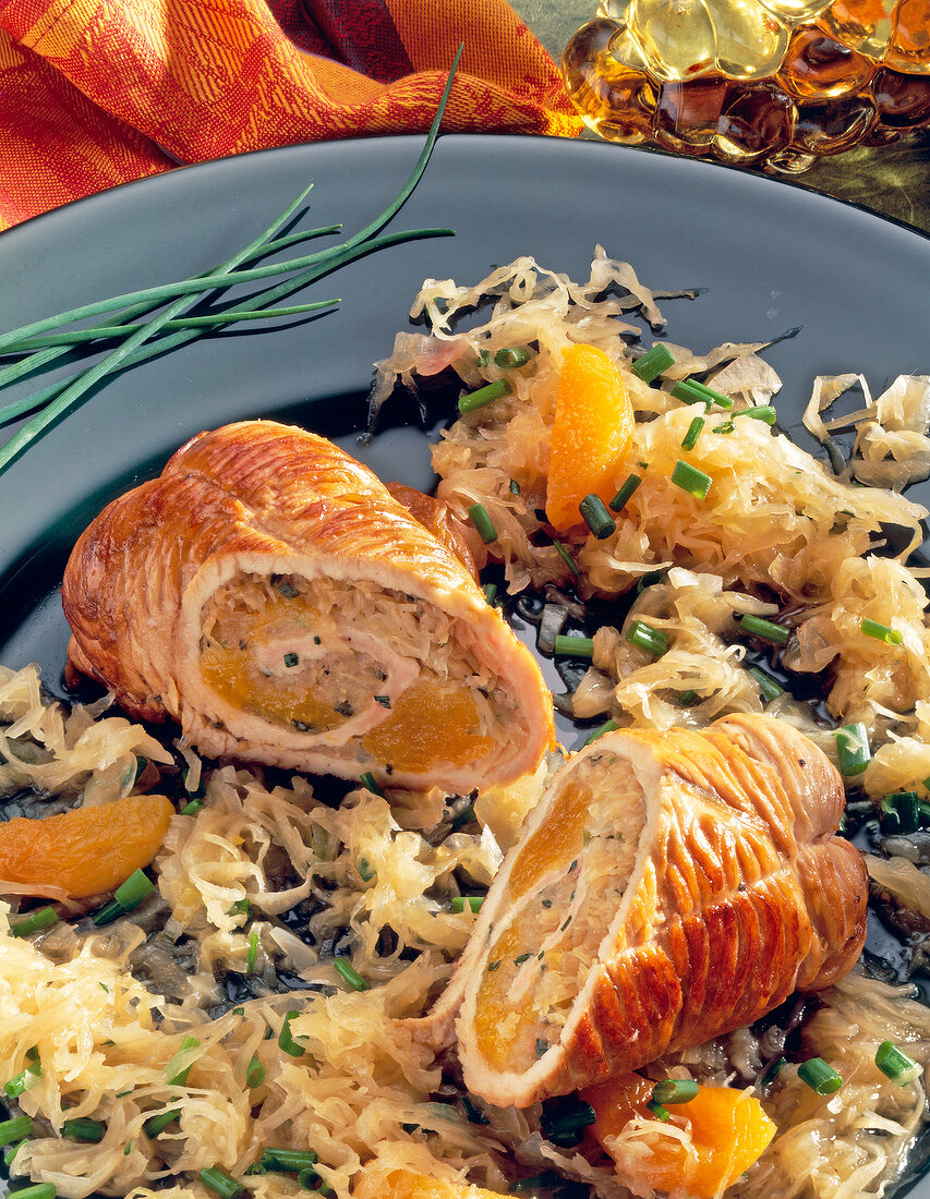 Close-up of turkey roll with sauerkraut and chives on plate