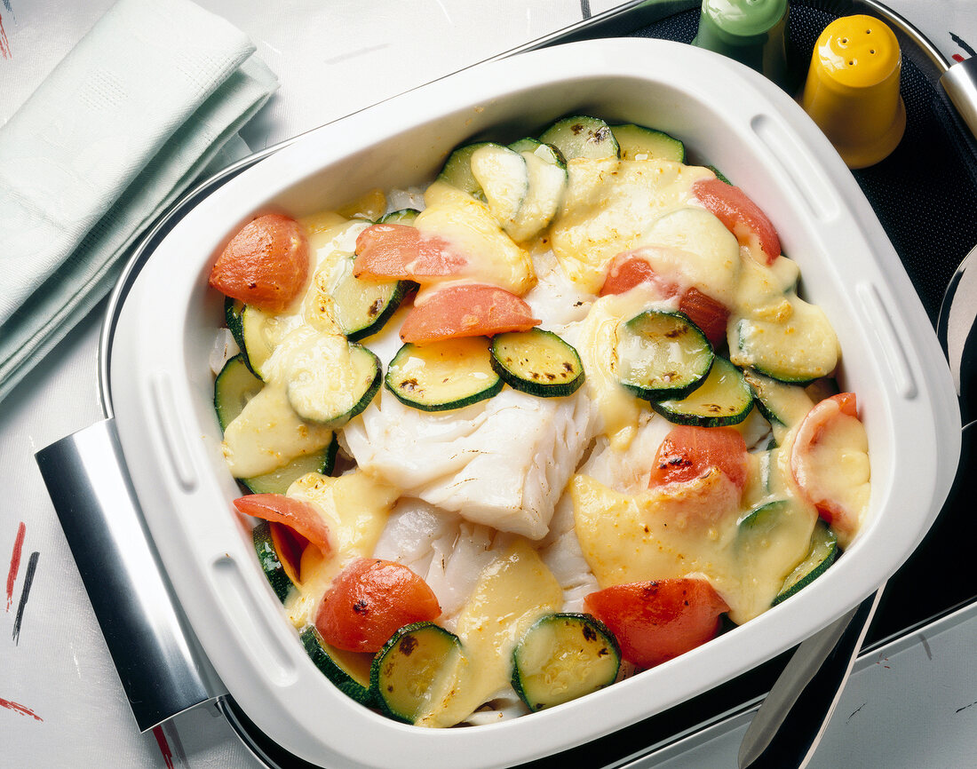Cod with zucchini and tomatoes in casserole