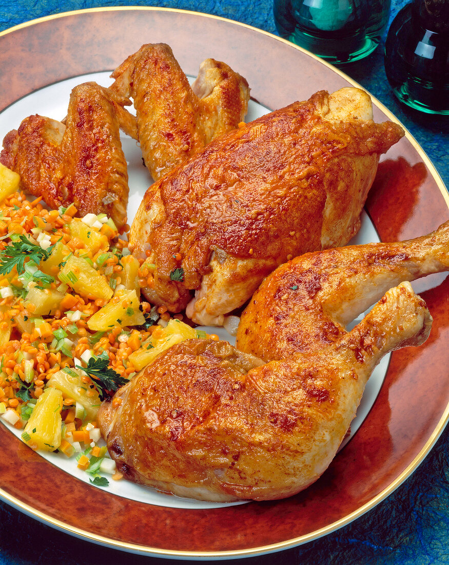 Close-up of chicken with lentils, vegetables and pineapple vegetables on plate