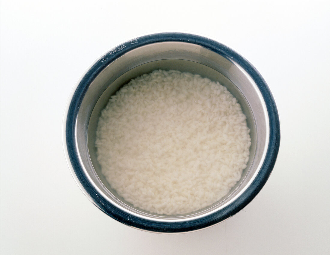 Soaked rice in bowl on white background