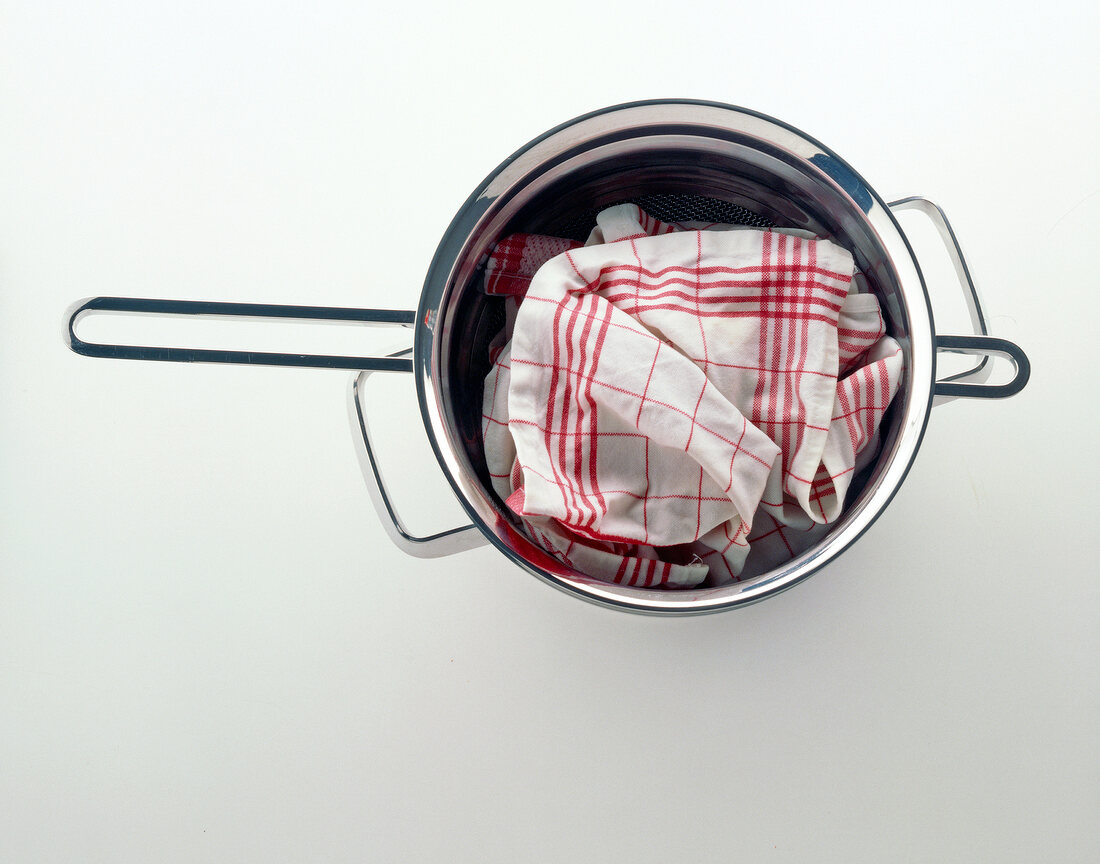 Cooked rice in steamer and covered with cloth on white background