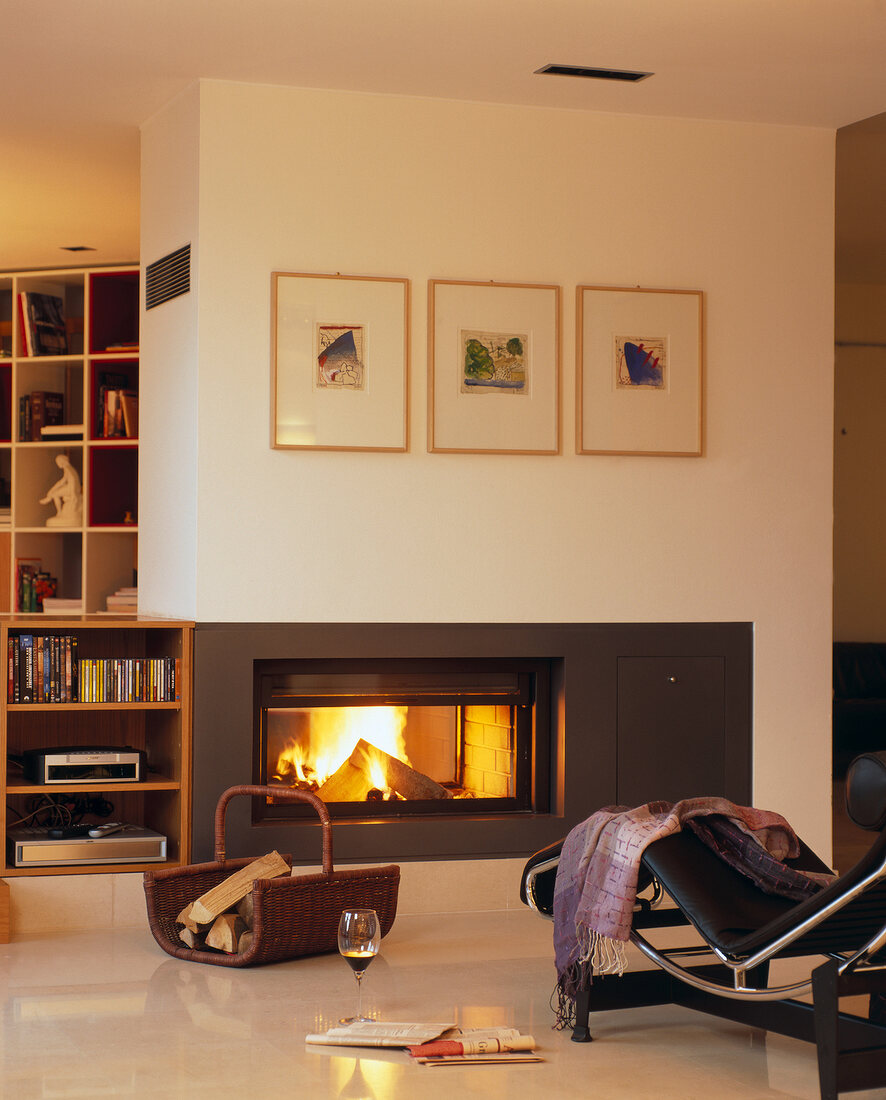 Room with shelf, fire place and picture frames hanging on wall