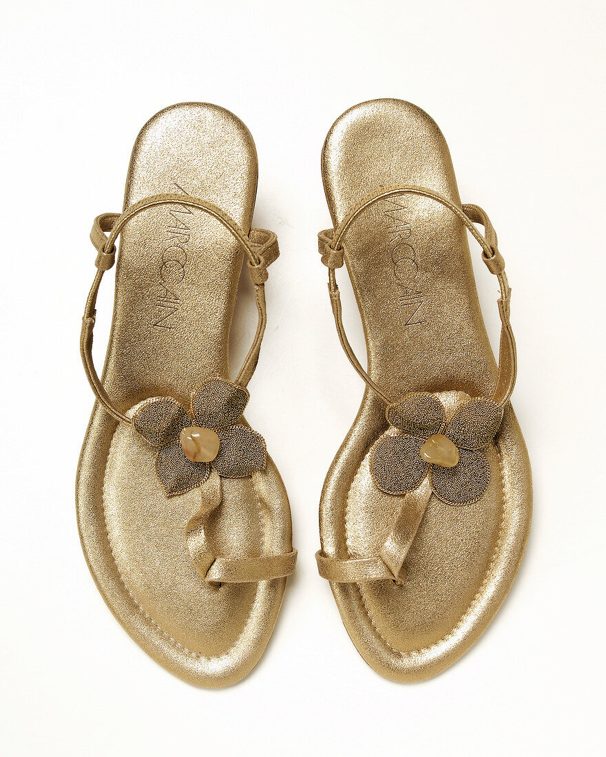 Golden toe sandals on white background