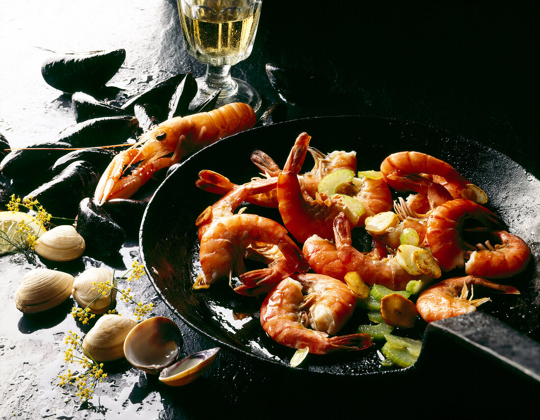 Shrimp, lobster and mussels in pan on black background