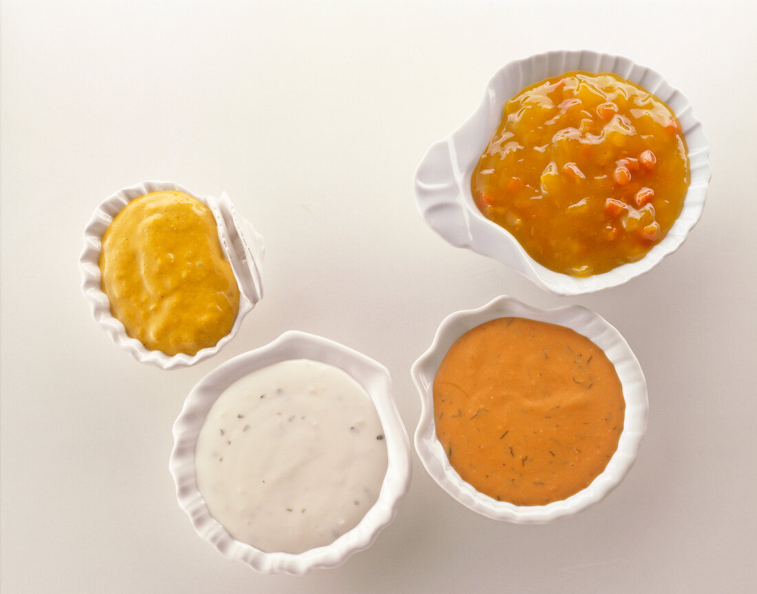 Four sauces for seafood in shell shaped sauce boats, overhead view