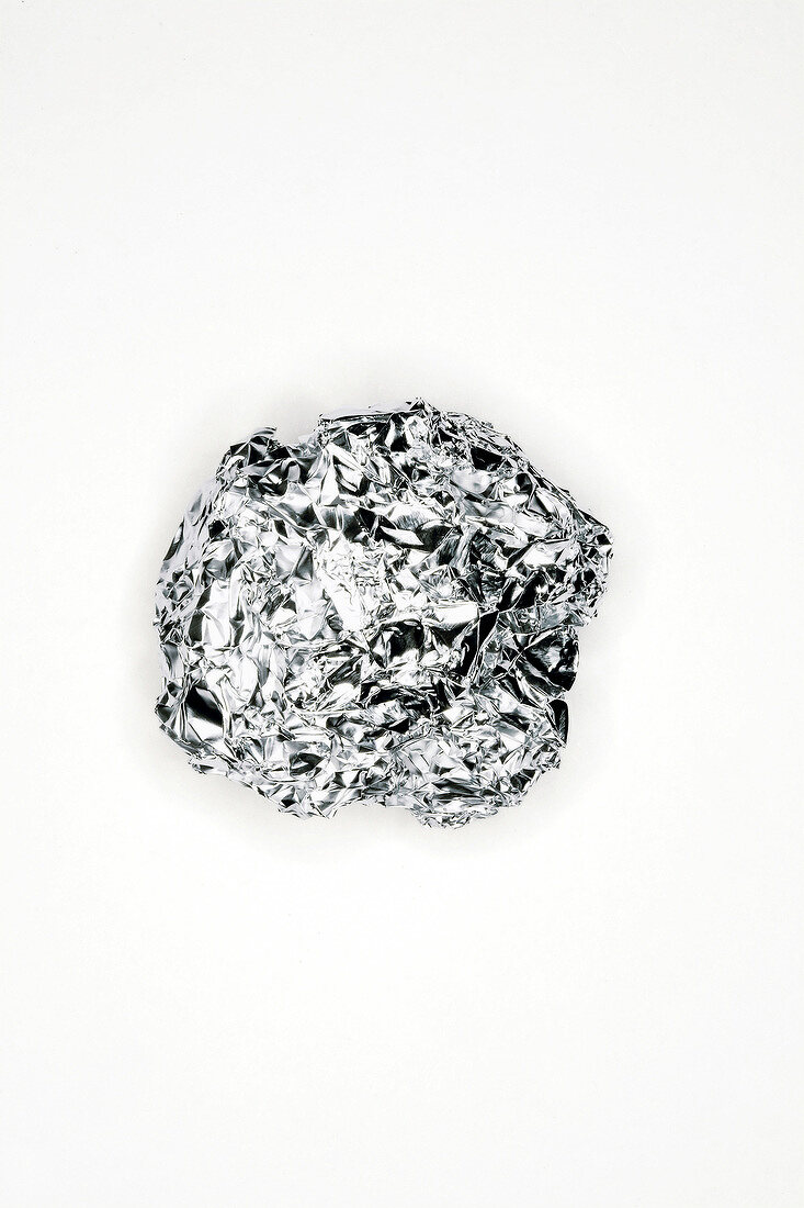 Close-up of crumpled tin foil on white background