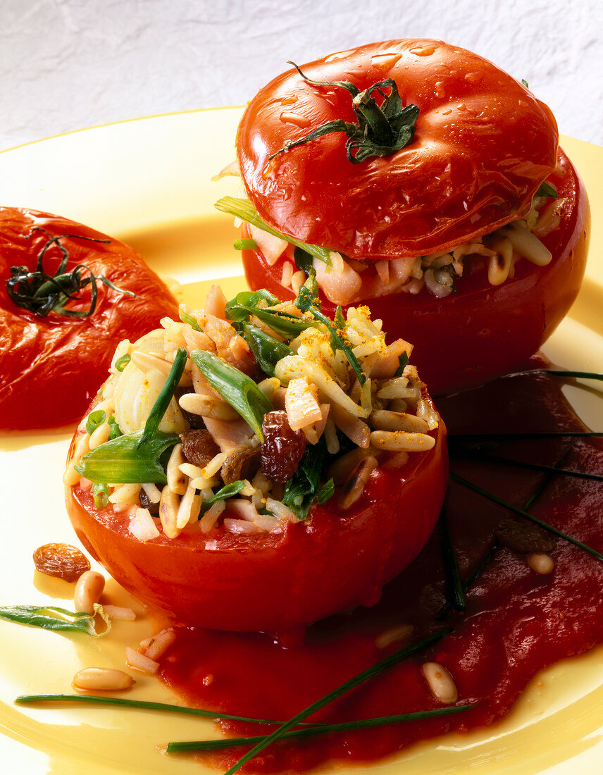 Close-up of stuffed tomatoes with curry rice on yellow plate
