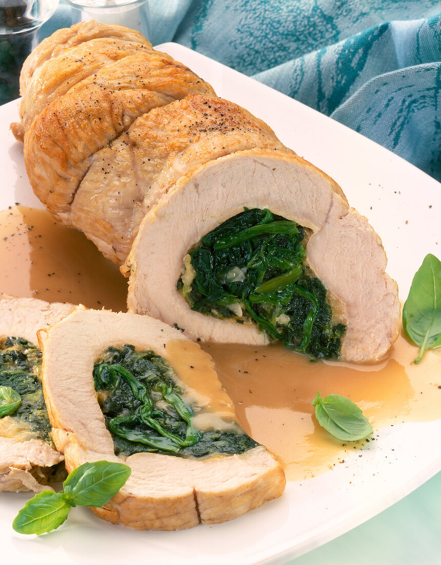 Sliced roast turkey stuffed with spinach on plate