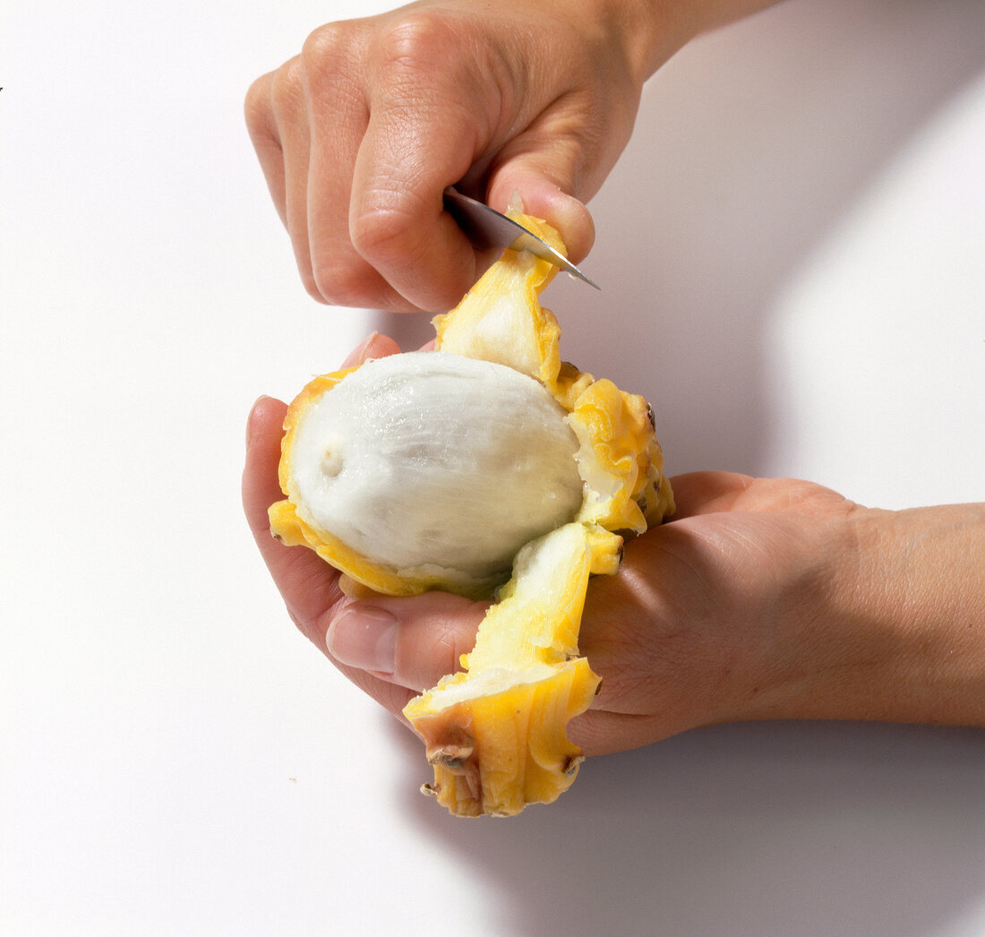 Pitahaya being peeled with knife, step 1