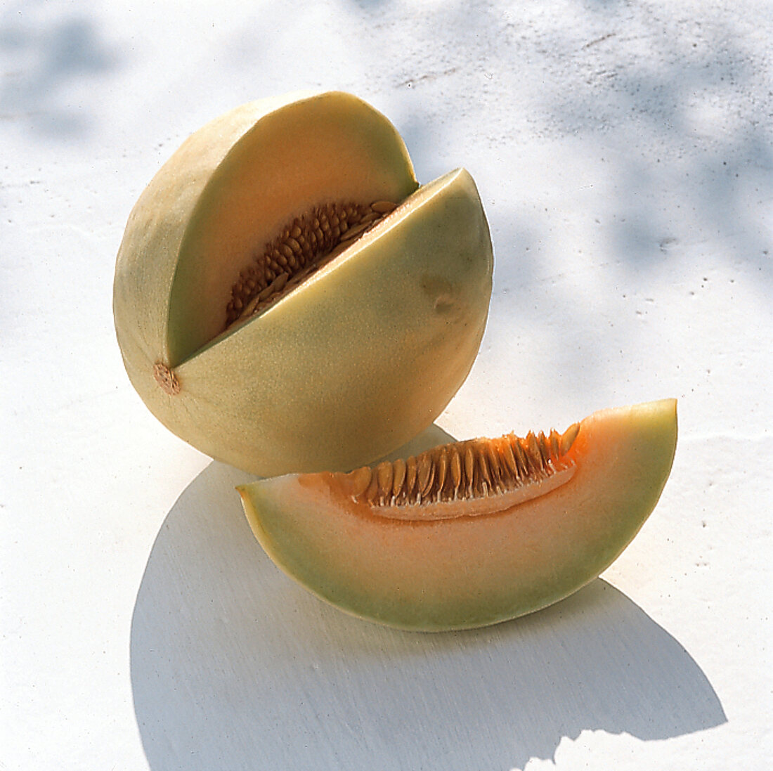 Honey dew cantaloupe with slice cut out on white surface