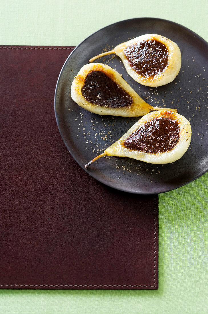 Pears stuffed with chocolate and creme brulee served on plate