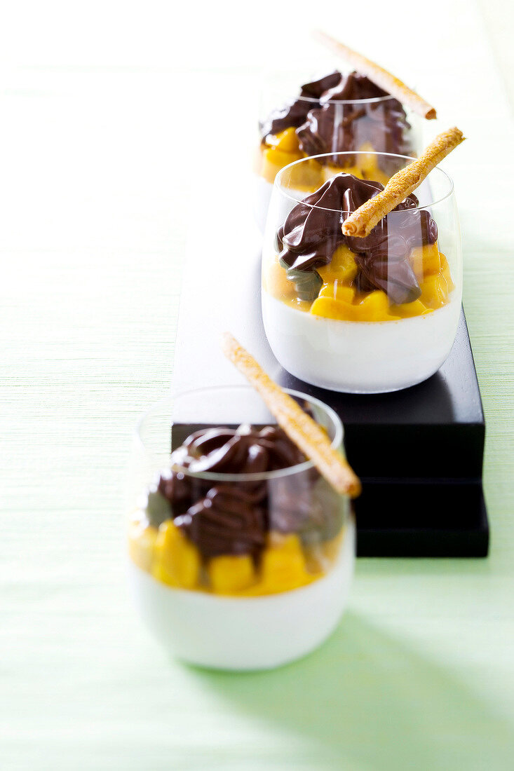 Chocolate foam and panna cotta with coconut and mango curry in glasses