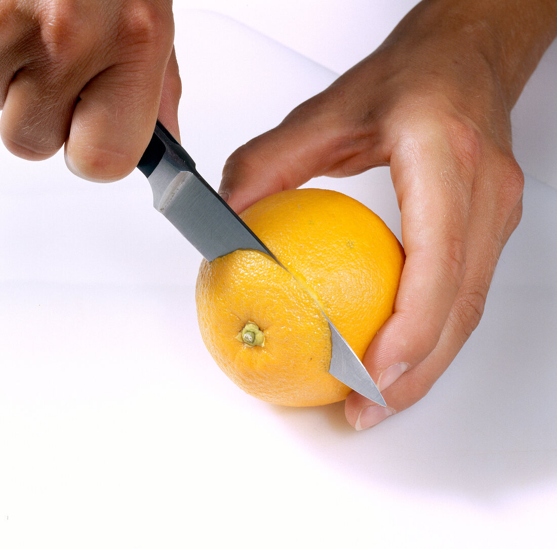 Orange being cut with knife, step 1