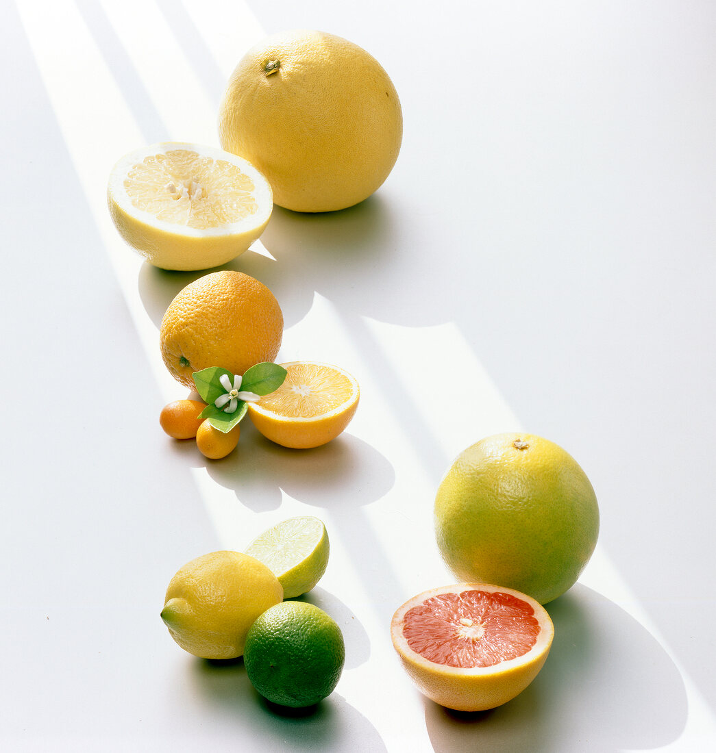 Halved and whole orange, lime, lemon and citrus on white background