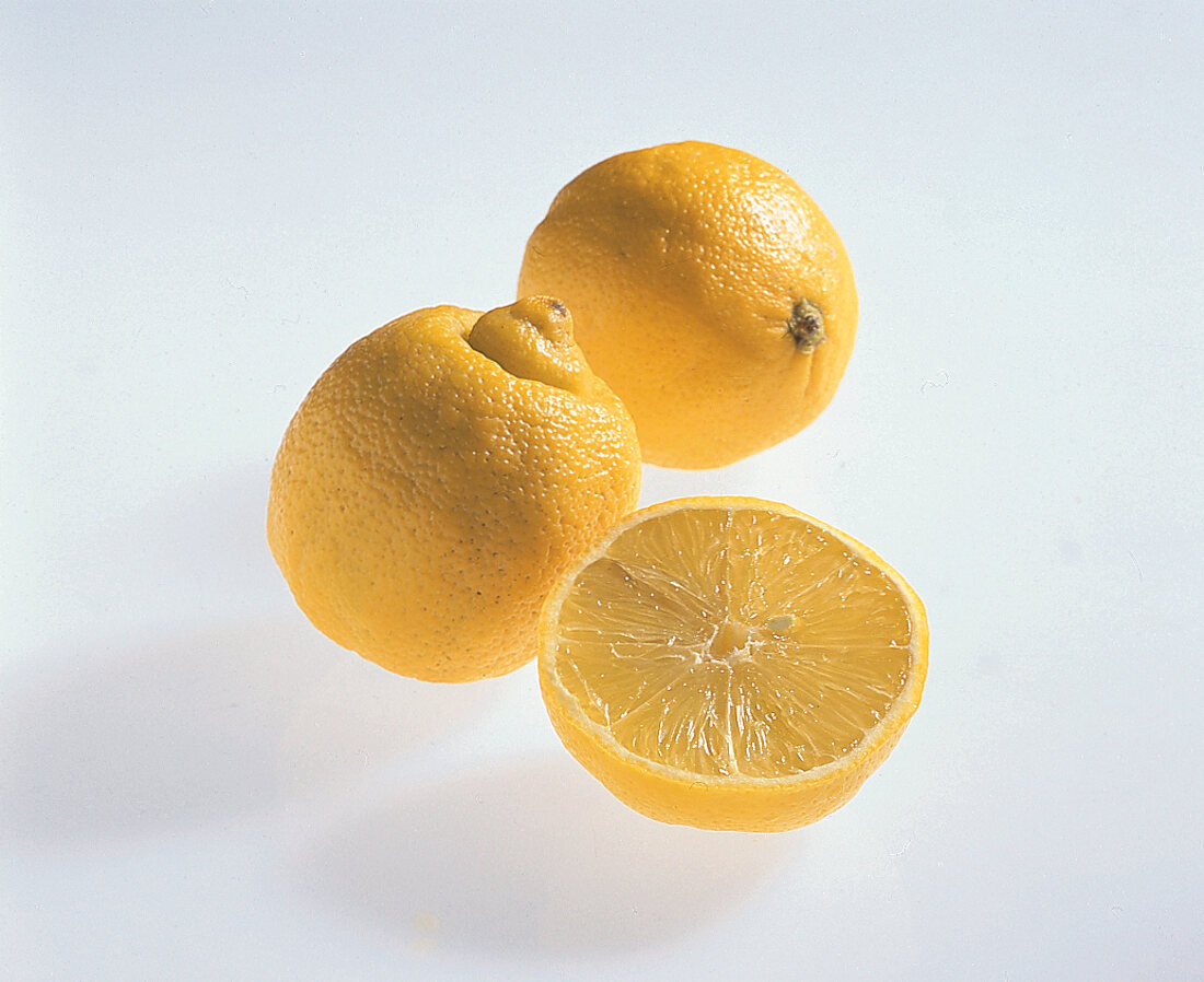 Whole and halved bergamot orange on white background