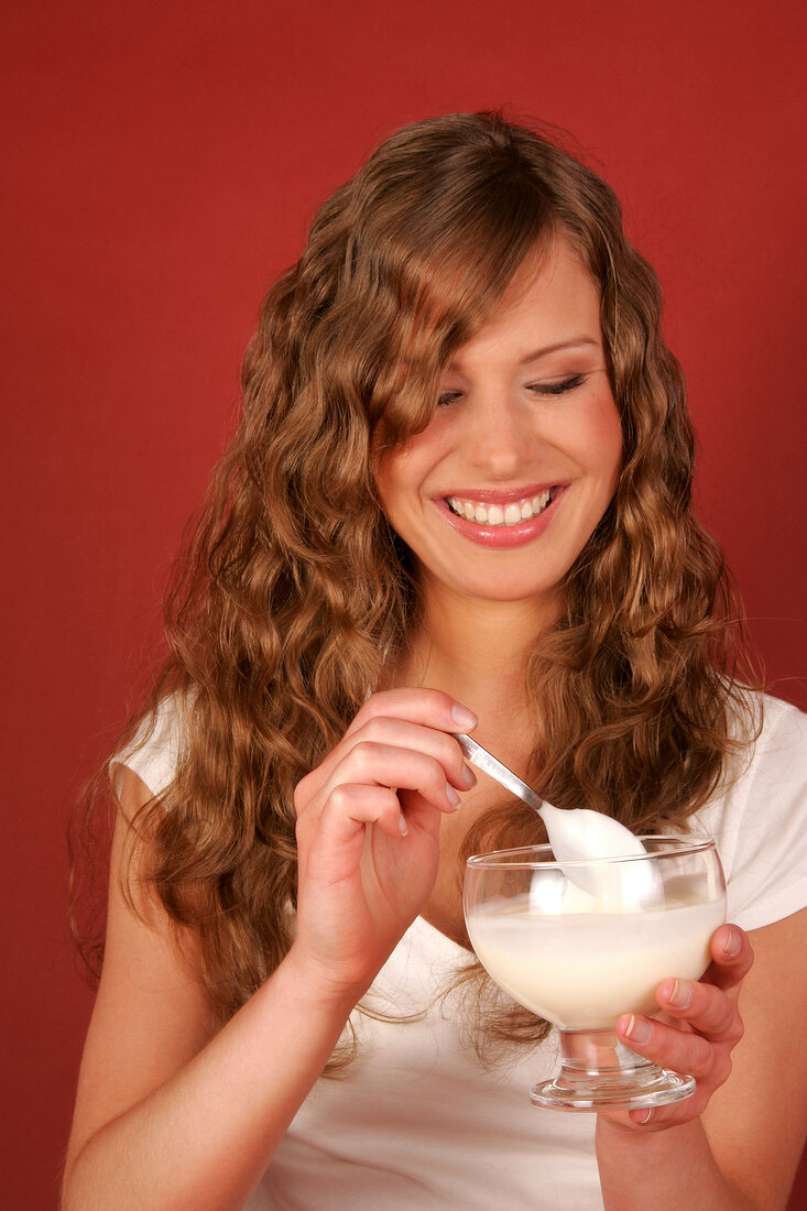Woman holding cup of dessert and smiling