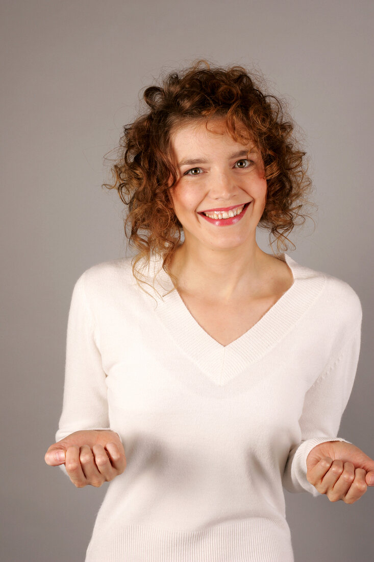 Portrait of sad woman with curly hair wearing white sweater