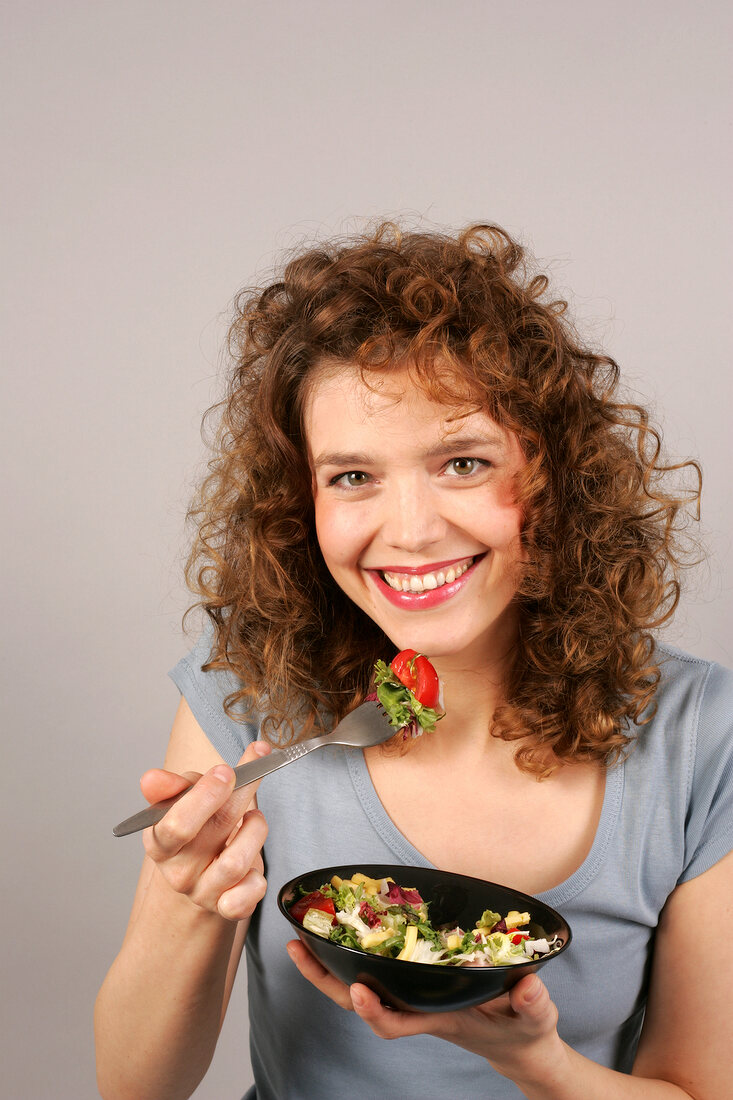 Janine schaut in die Kamera hält Salatschüssel in der Hand