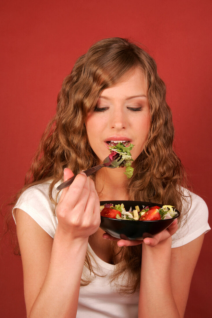 Sandra hält Schale mit Salat und Gabel in der Hand
