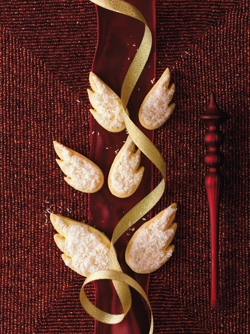 Wing-shaped biscuits decorated with icing sugar and grated coconut
