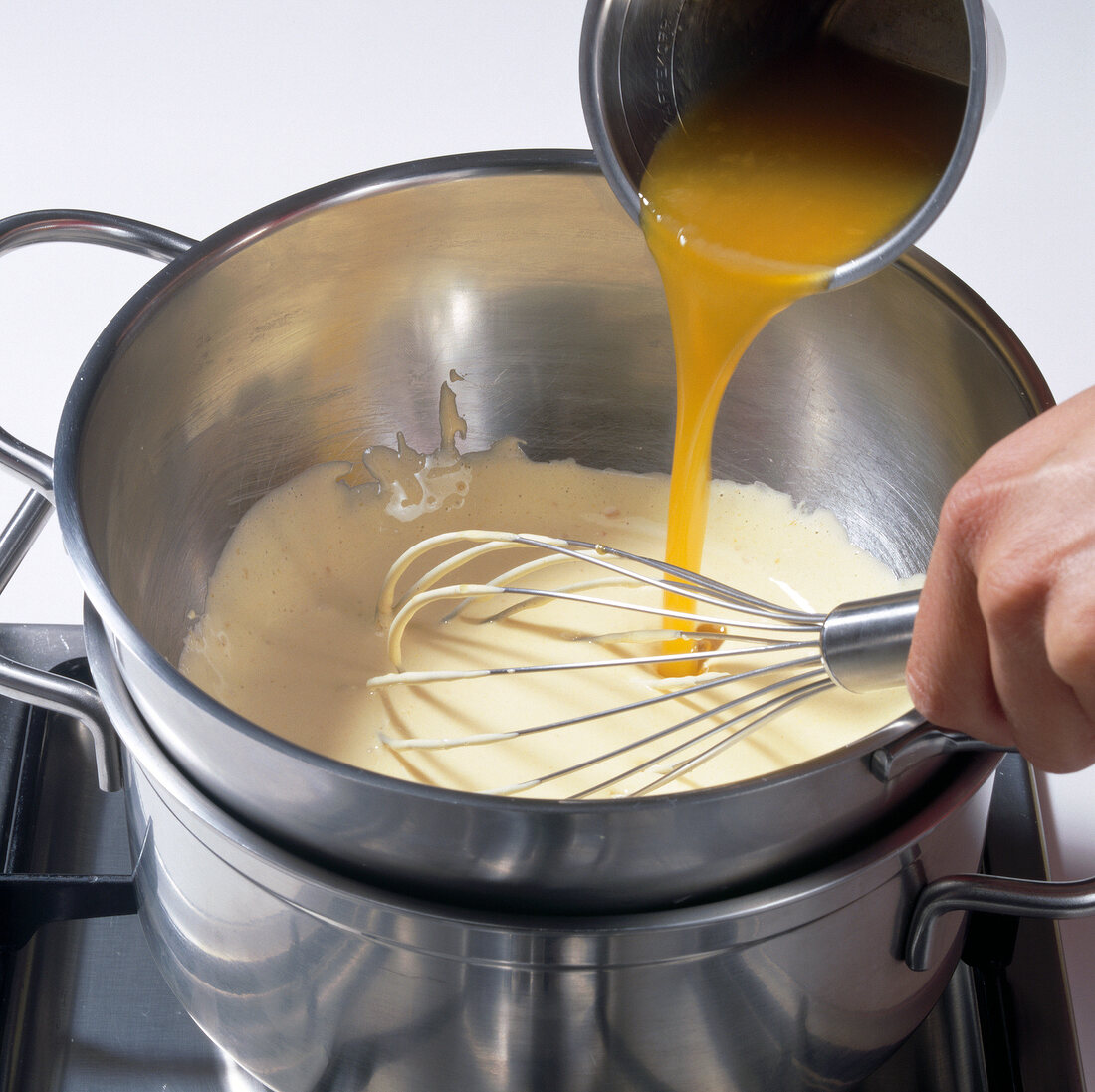 Pouring passion fruit juice into egg and whisking