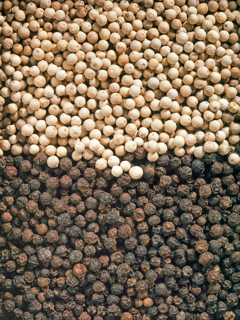 Close-up of black and white peppercorns