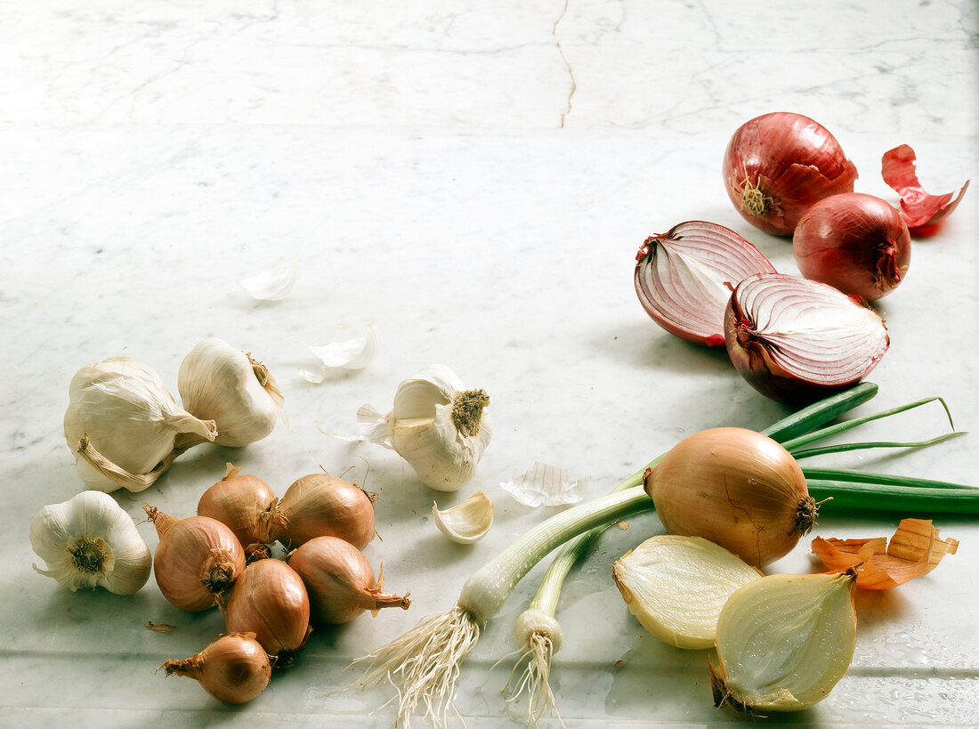 Various onions and garlic bulbs on white background