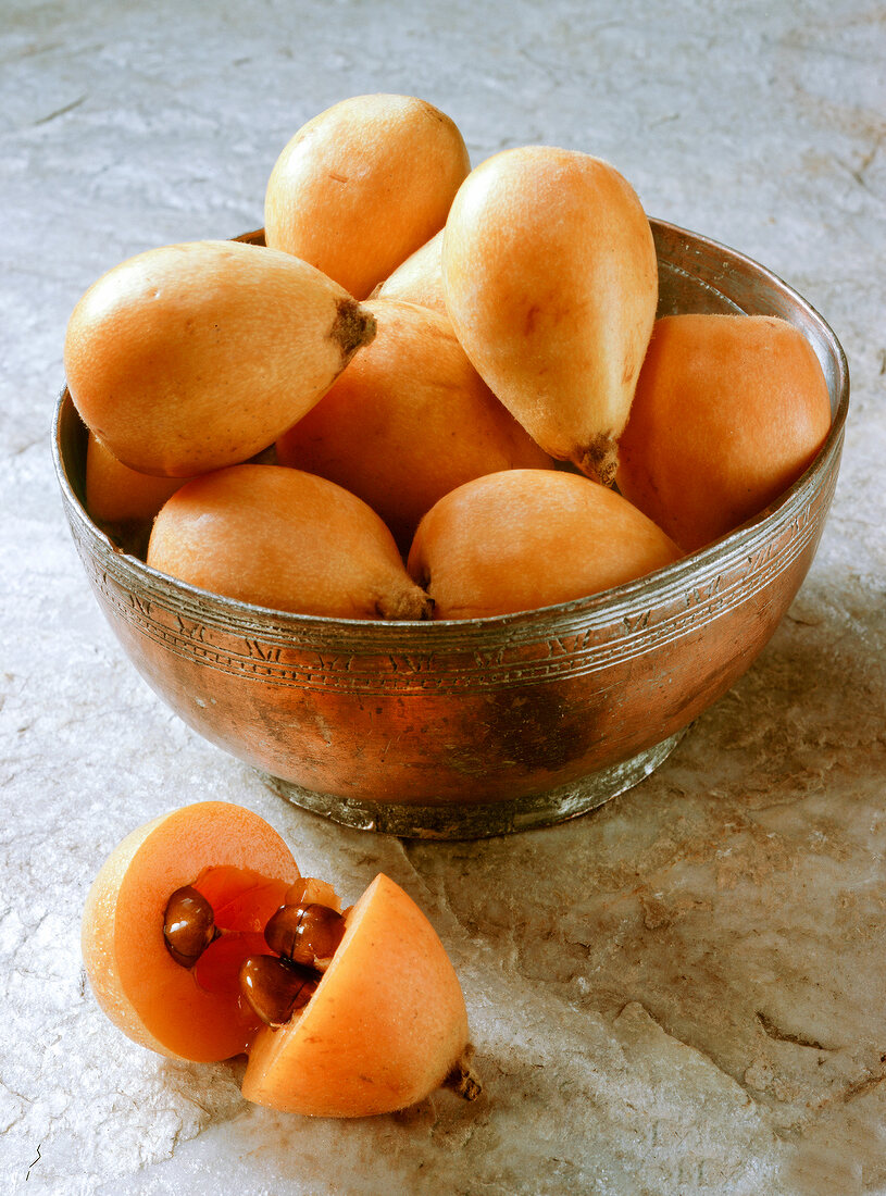 Whole and halved loquat in bowl