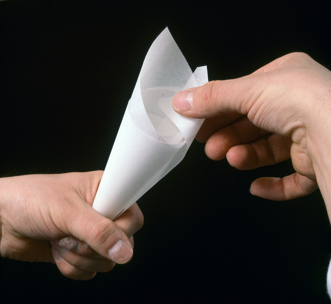 Close-up of hand fixing piping bag, step 3