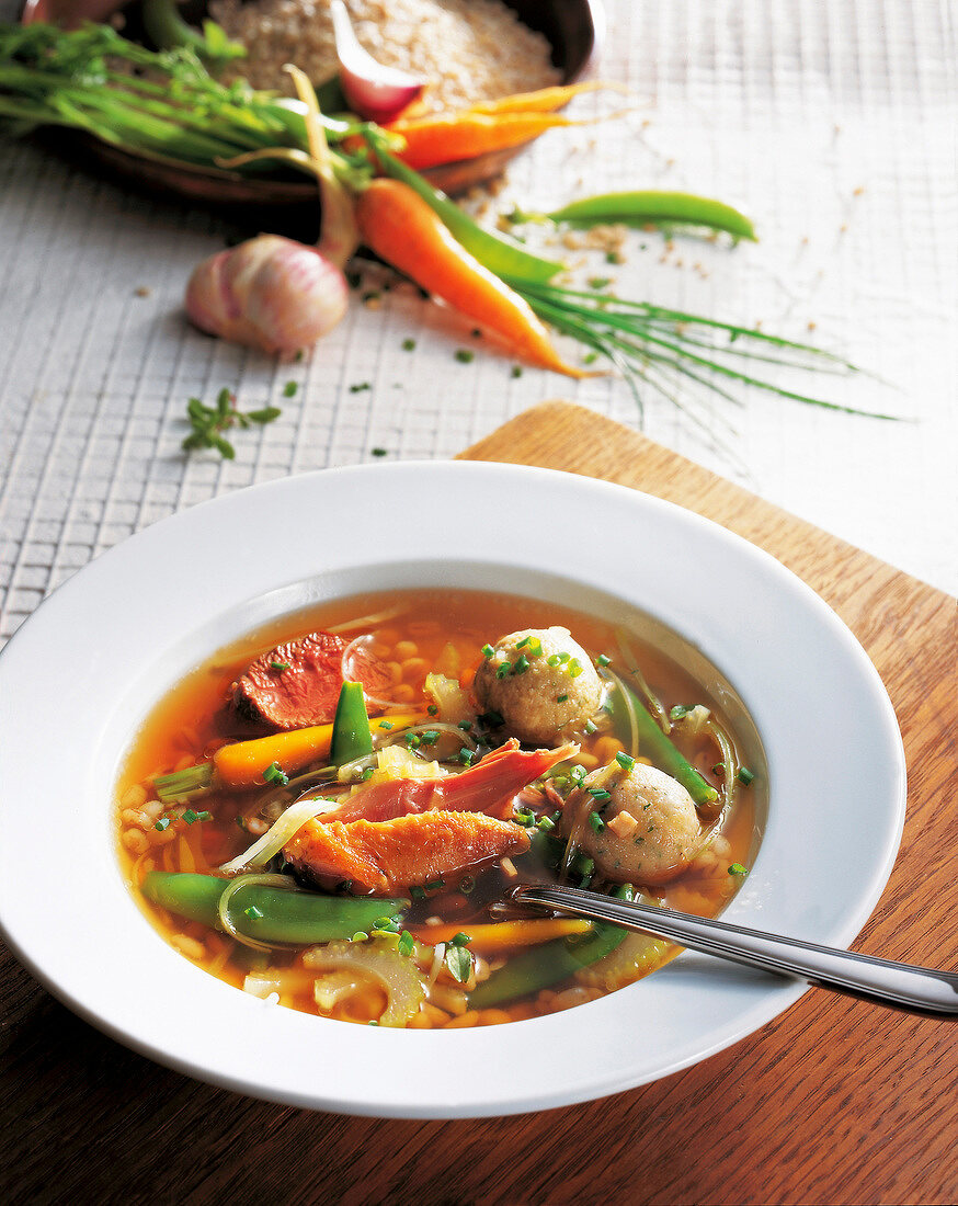 Pot-au-feu with deer, pheasant and vegetables on plate