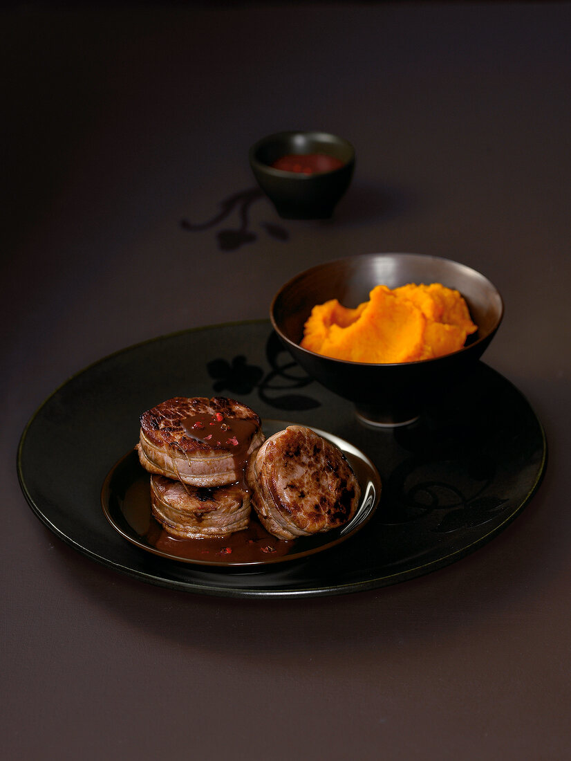 Medallions with chocolate sauce and pumpkin puree on plate