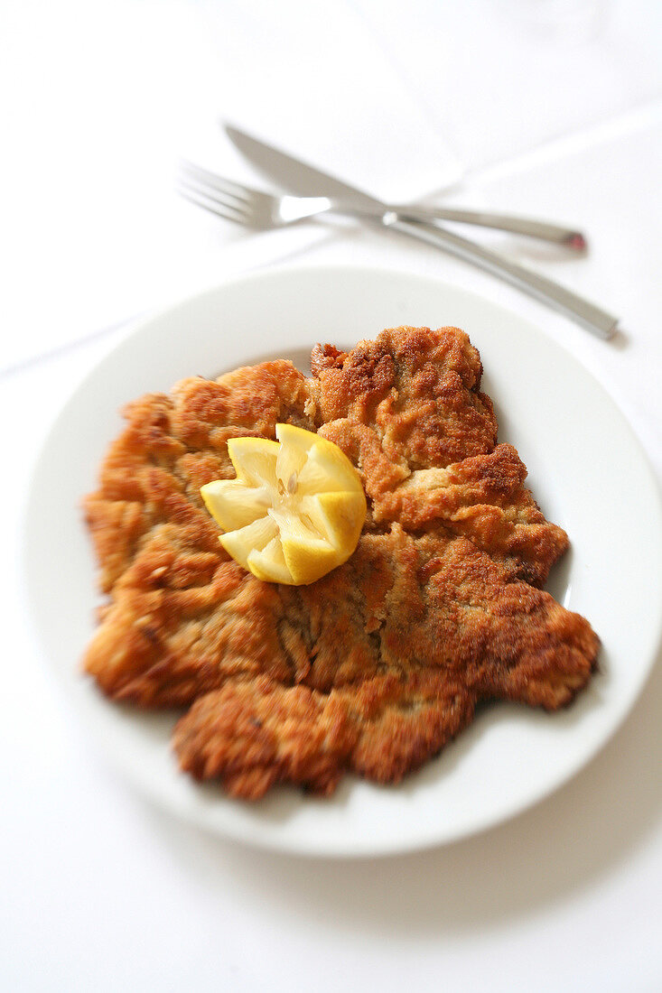 Wiener Schnitzel with lemon toppings on plate