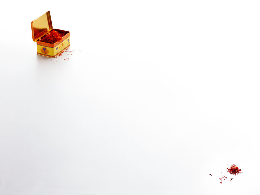 Saffron threads in container and on white background, copy space