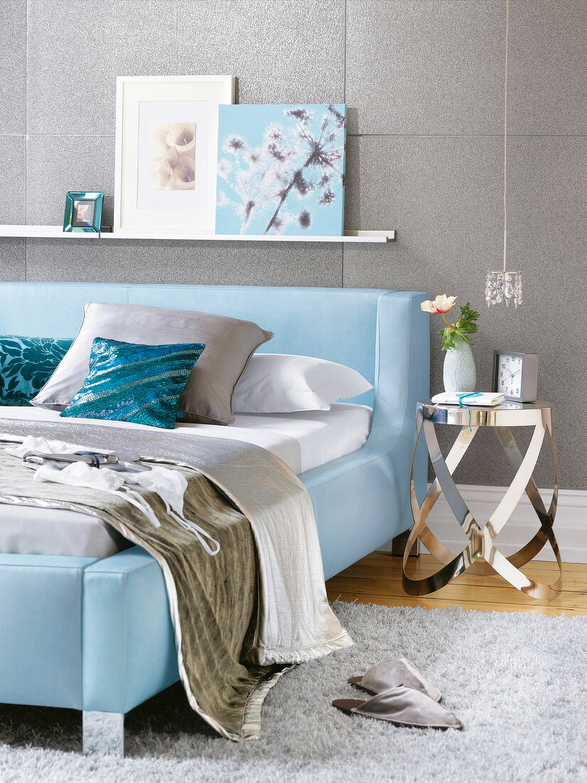 Bedroom with blue leather bed and grey wallpaper with glass beads