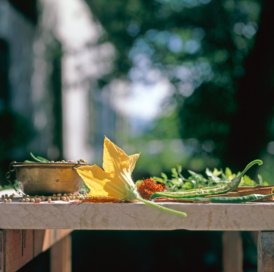 Zucchini flower, green chilli peppers, chickpeas and saffron on table