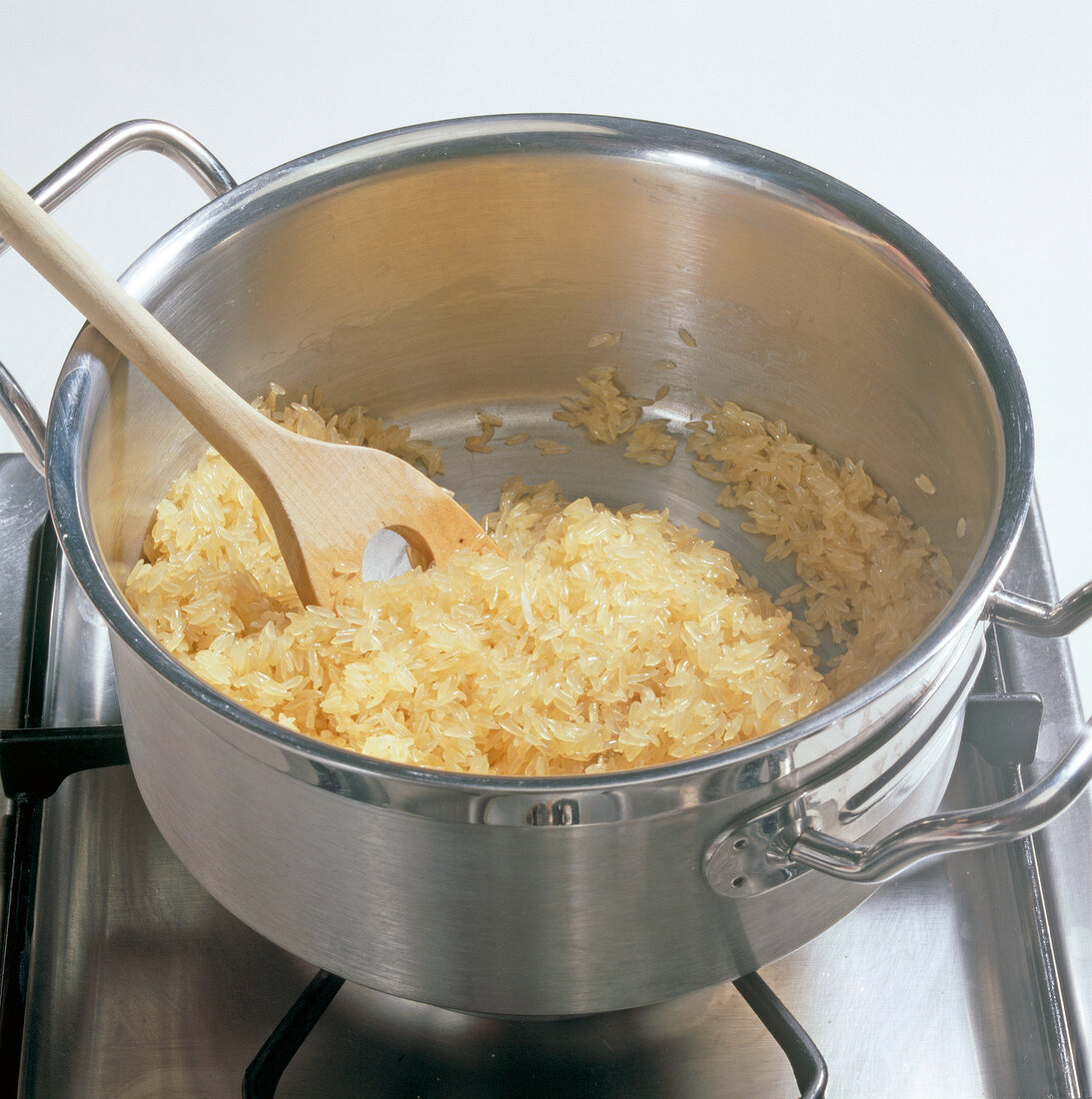 Long grain rice with butter being sauteed in casserole, step 1