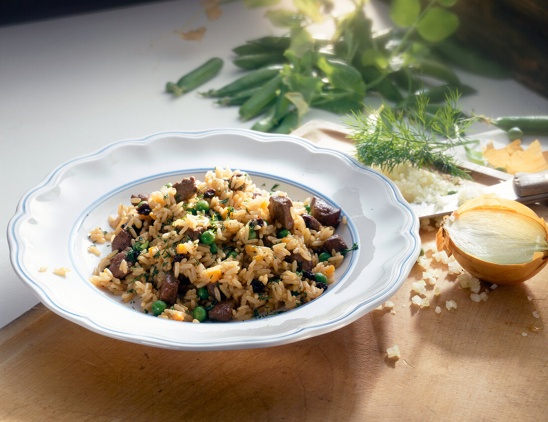 Rice with lamb liver and peas on plate