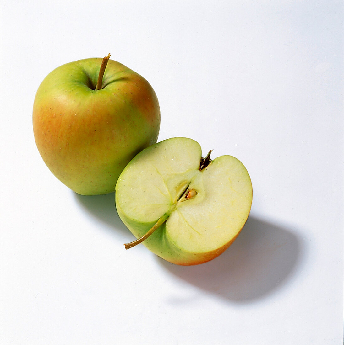 Whole and halved apples on white background
