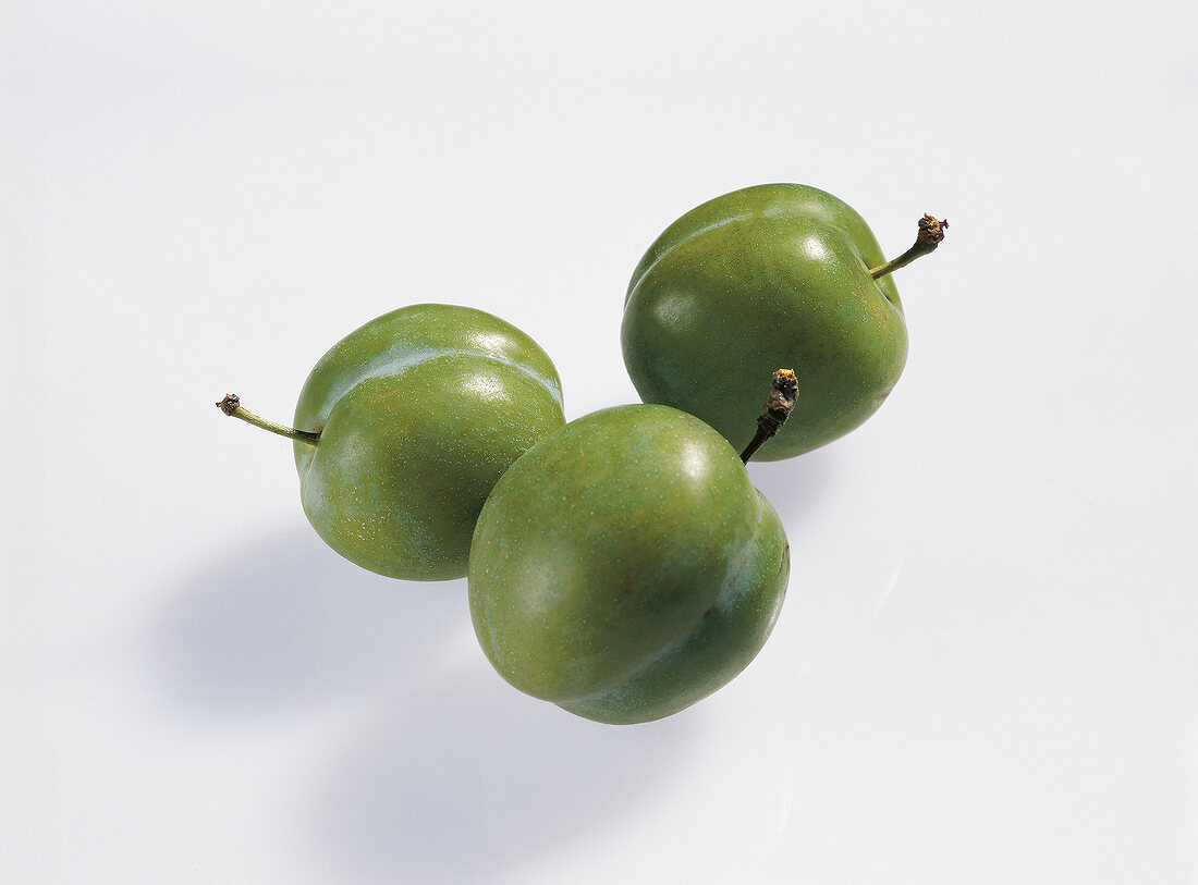 Three greengage on white background