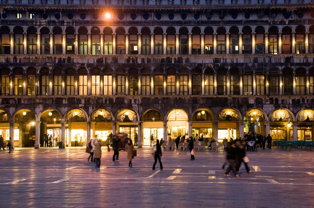Buildings with illuminated arcades at Saint Mark's Square in evening, Venice, Italy