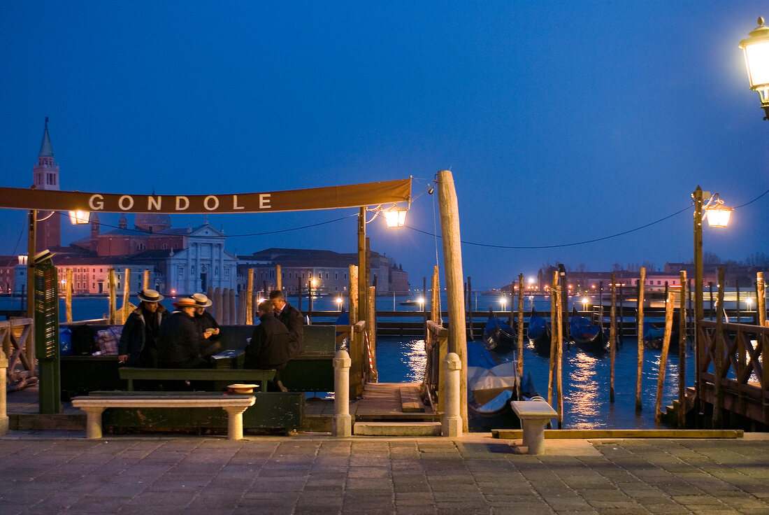 Gondoliers playing cards at Saint Mark's Square in evening, Venice, Italy