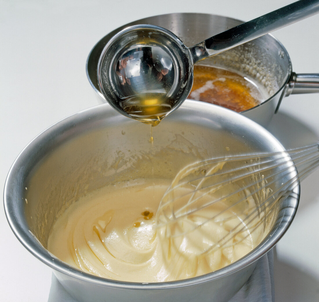 Melted butter being added with spoon in bowl of mixture, step 8