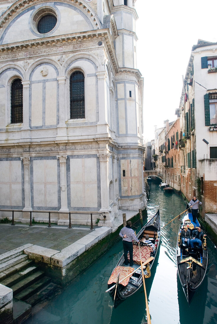 Facade of Santa Maria dei Miracoli church and two gondolas in narrow canal, Venice, Italy