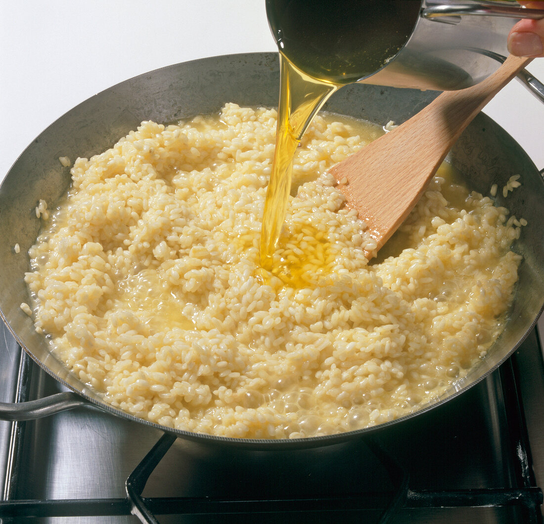 Close-up of lafond wine being poured on cooked rice in pan, step 4