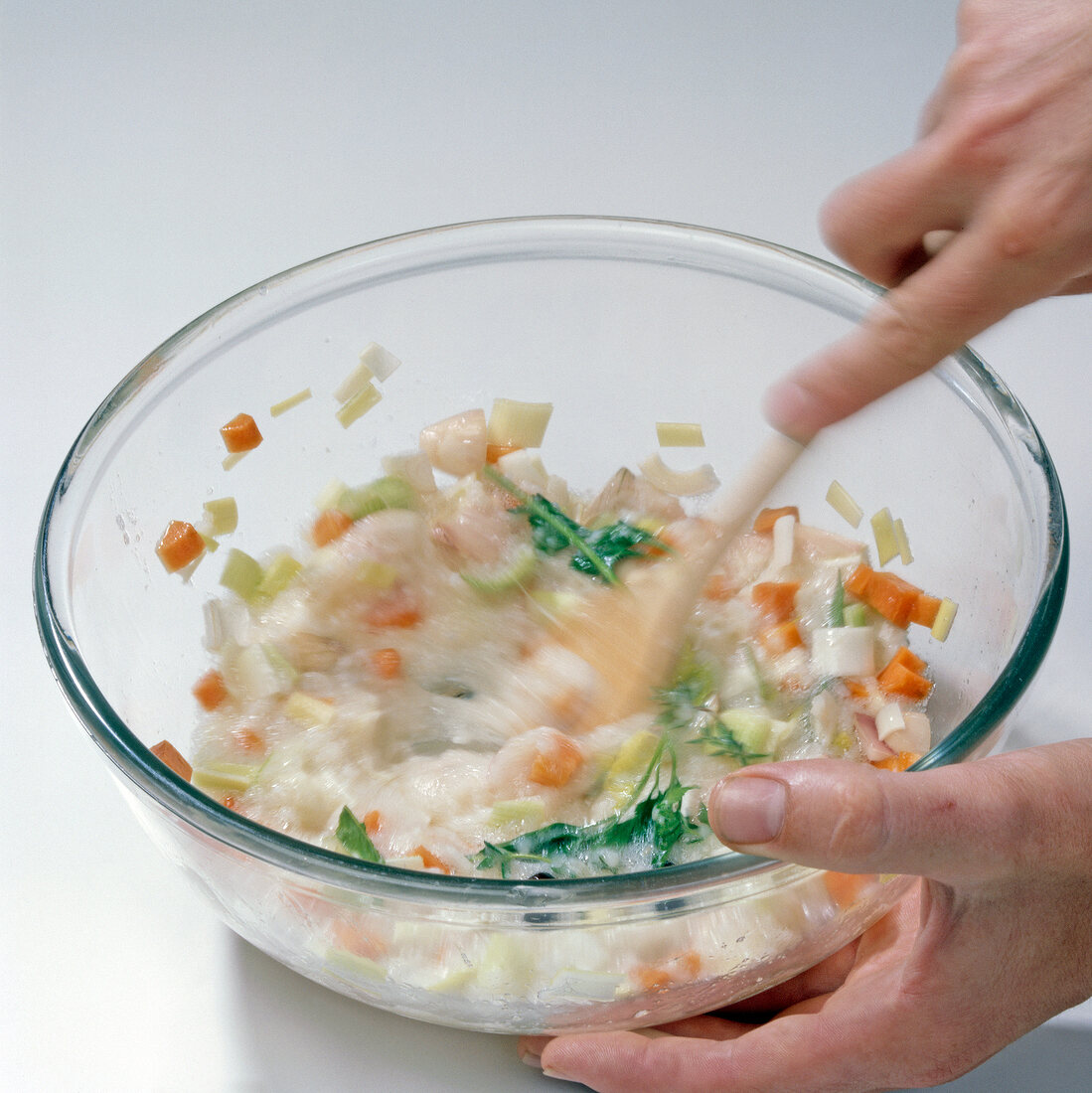 Close-up of hand mixing ingredients in bowl, blurred motion, step 3