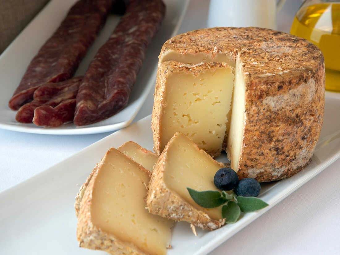 Round yellow cheese from Pyrenees on plate